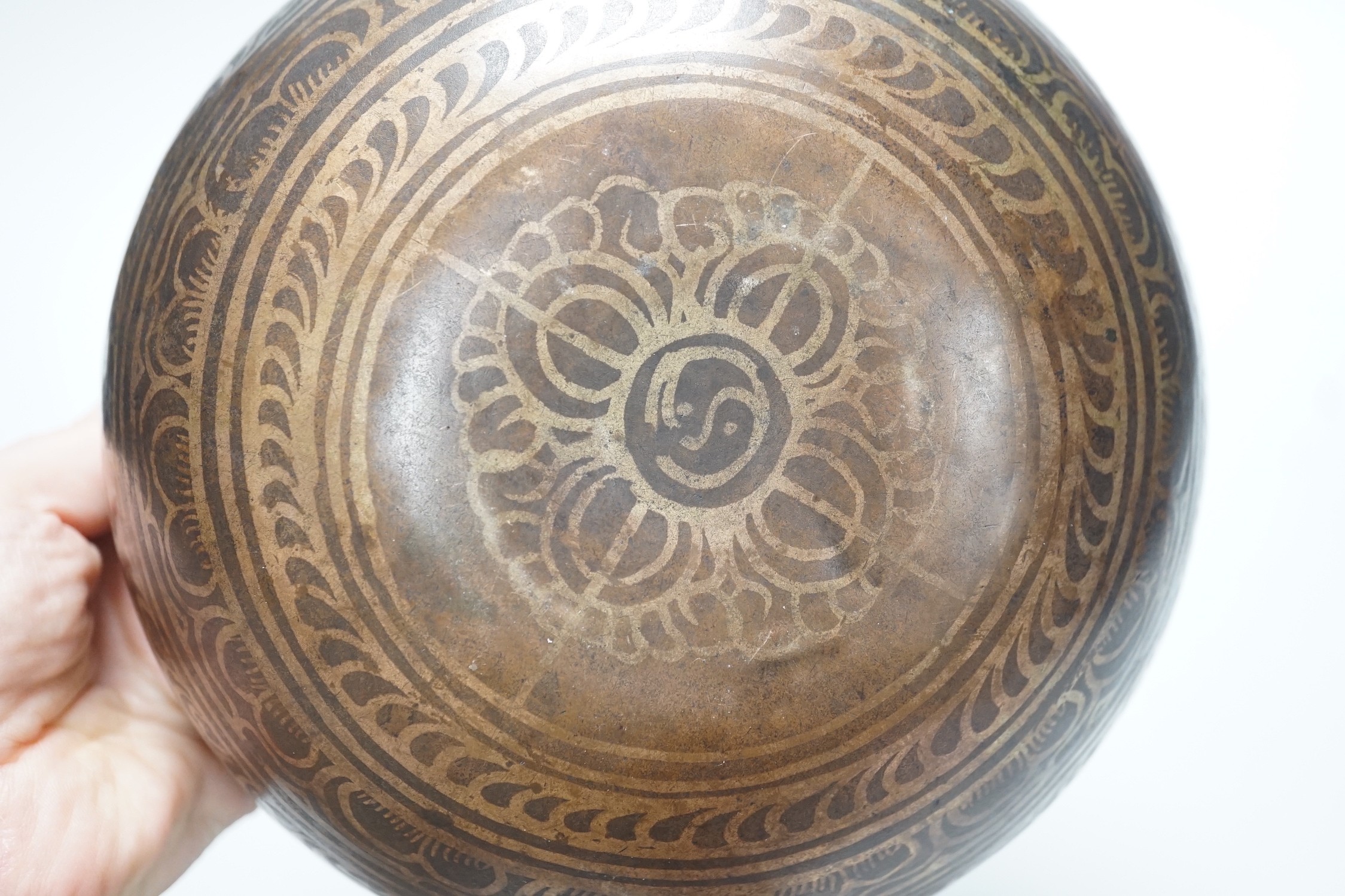A bronze Nepalese temple bowl decorated with script, 18cm diameter